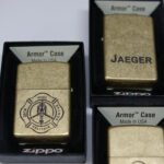 Three zippo lighters in boxes with a fire department logo.