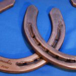 A pair of horse shoes with the name " whiskies " engraved on them.