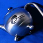 A silver tea pot with the logo of automated engineering.