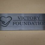 A metal sign that says victory foundation.