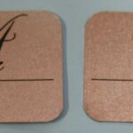 A pair of brown paper tags with the word " love " written on them.