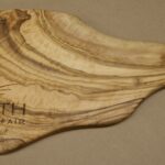 A wooden cutting board with the words " earth fair ".