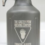 A growler with the grizzly paw brewing company logo on it.