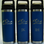 Three blue thermos bottles with a handle.