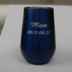 A blue cup with the name mom and date of birth.