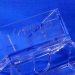 A close up of the bottom portion of a clear plastic object.