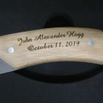 A wooden handle with the name john alexander hogg engraved on it.