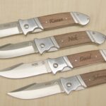 A set of five knives with engraved names on them.