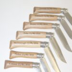 A bunch of knives with engraved names on them