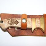 A knife with a leather sheath on it.