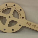A wooden paddle with the words fuel pickup relocation on it.