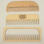 A set of three wooden combs with different sizes.