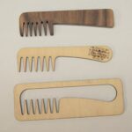 A set of three wooden combs with different designs.