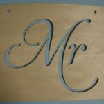 A wooden sign with the letter m on it.