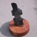 A wooden base with a metal object on top of it.