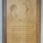 A wooden plaque with an image of two people shaking hands.