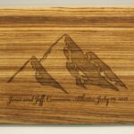 A wooden cutting board with an image of mountains.