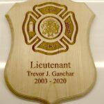 A wooden plaque with the name of a firefighter and the date of his birth.
