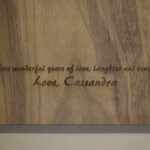 A close up of the words engraved on the side of a cutting board.