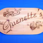 A wooden plaque with some pictures of animals and cars