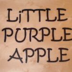 A picture of the words little purple apple written in black ink.