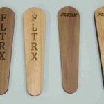 Four wooden spoons with the words " fltrx " engraved on them.