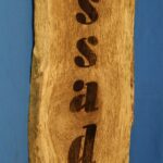 A wooden sign with the word " saag " written on it.