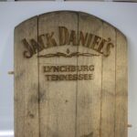 A wooden sign with the words jack daniel 's lynchburg tennessee written on it.