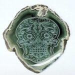 A green skull shaped plate sitting on top of a table.