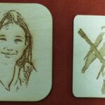 A wooden coaster with a picture of a girl and an image of a person.